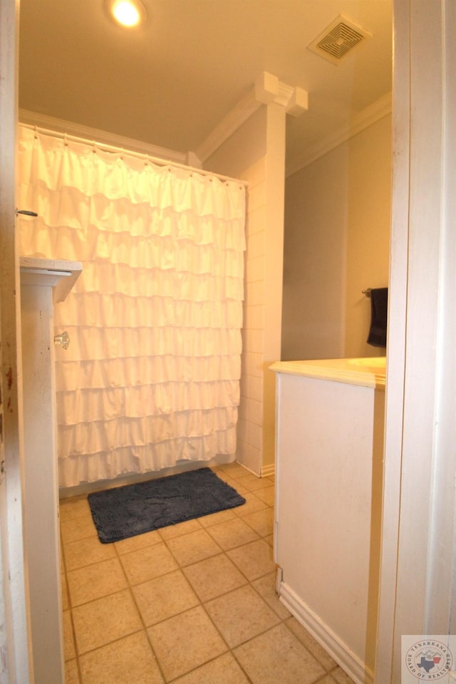 bathroom with tile patterned flooring and ornamental molding