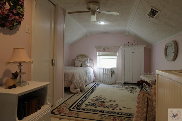 bedroom with a textured ceiling, vaulted ceiling, and ceiling fan