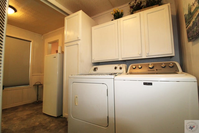 washroom with cabinets and washing machine and clothes dryer