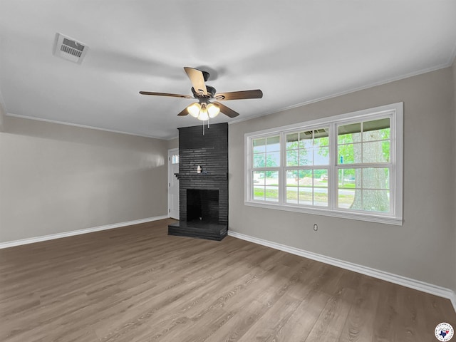 202 Main St, Hooks, TX 75561 - unfurnished living room featuring crown molding, a ceiling fan, baseboards, wood finished floors, and a brick fireplace