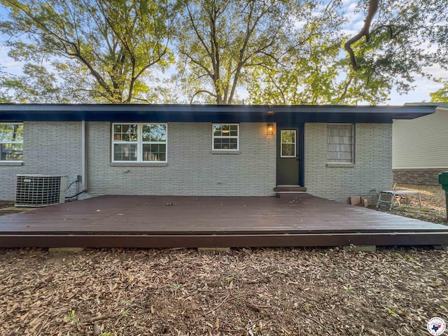 202 Main St, Hooks, TX 75561 - rear view of property featuring cooling unit, brick siding, and a wooden deck