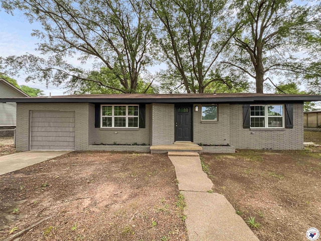 202 Main St, Hooks, TX 75561 - ranch-style house featuring brick siding, an attached garage, and driveway