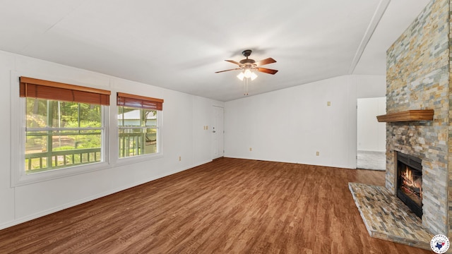 955 County Road 1124, Linden, TX 75563 - unfurnished living room featuring wood finished floors, a stone fireplace, and a ceiling fan