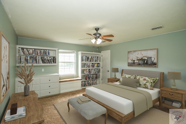 carpeted bedroom with ceiling fan and a textured ceiling