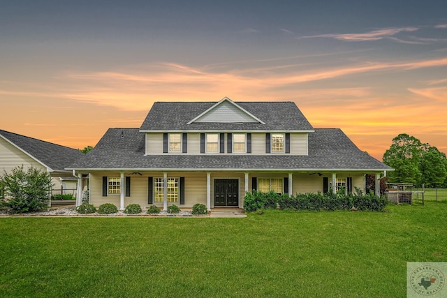 view of front of property with covered porch and a yard