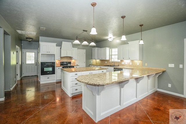 kitchen featuring kitchen peninsula, hanging light fixtures, white cabinetry, tasteful backsplash, and black appliances