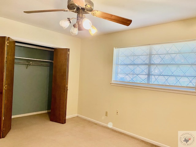 unfurnished bedroom featuring light colored carpet, a closet, and ceiling fan