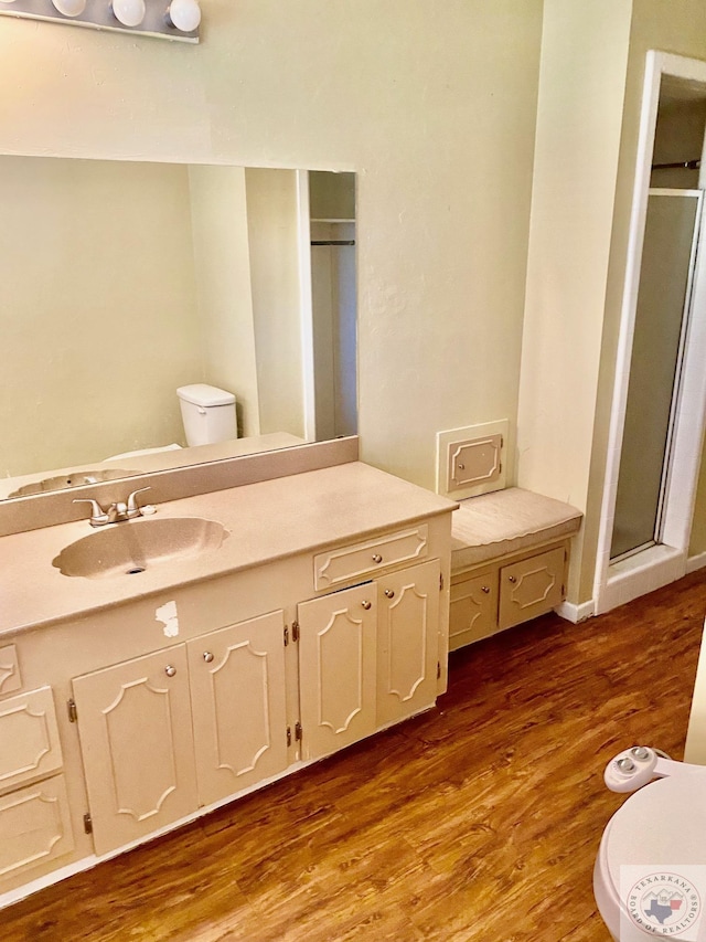 bathroom with hardwood / wood-style flooring, toilet, and vanity