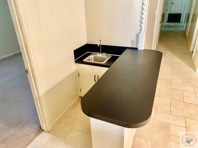 kitchen featuring sink, white cabinetry, and light colored carpet