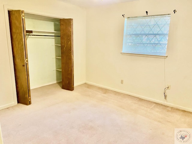 unfurnished bedroom featuring light colored carpet and a closet