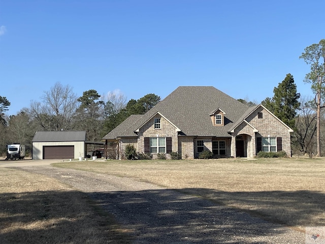 view of front of home with a garage, roof with shingles, an outdoor structure, and a front lawn