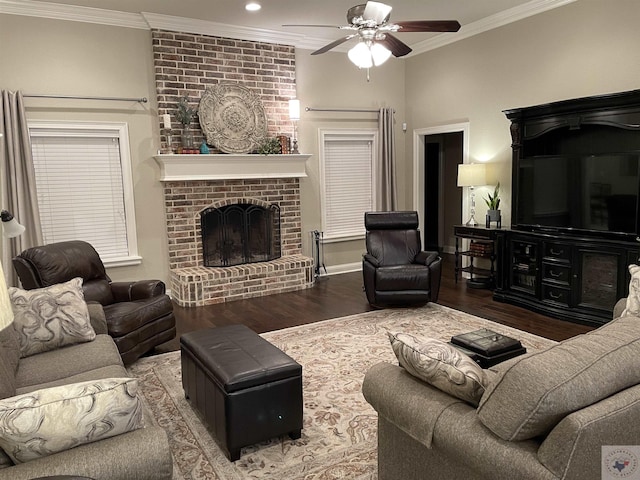 living area with a brick fireplace, ceiling fan, crown molding, and wood finished floors