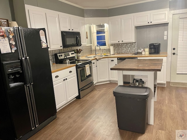 kitchen featuring white cabinetry, butcher block counters, light hardwood / wood-style flooring, and black appliances