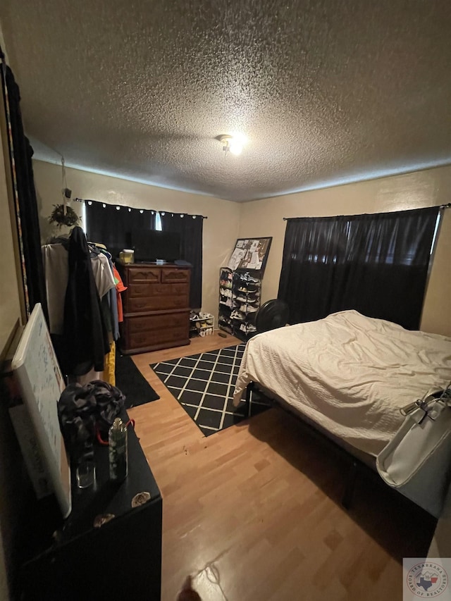 bedroom with hardwood / wood-style flooring and a textured ceiling