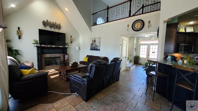 living room featuring high vaulted ceiling and french doors