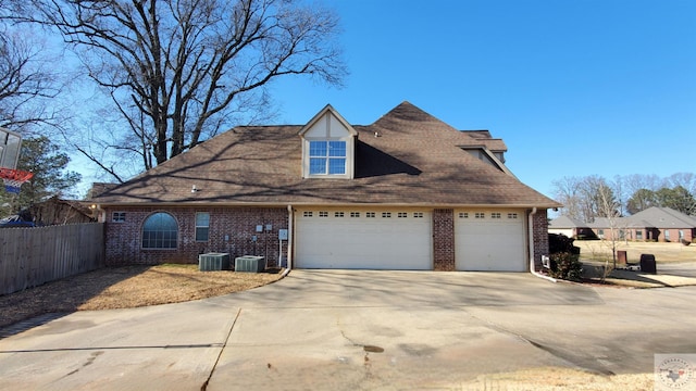 view of front of property featuring a garage and cooling unit