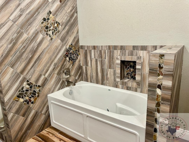 bathroom with tile walls and a bath