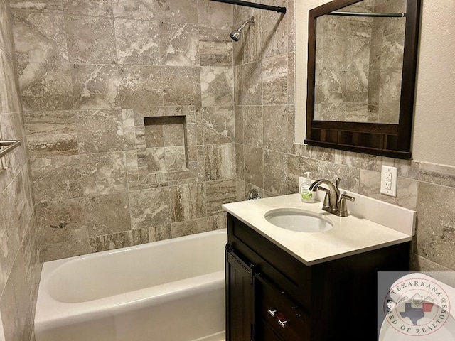 bathroom featuring vanity, tile walls, and tiled shower / bath