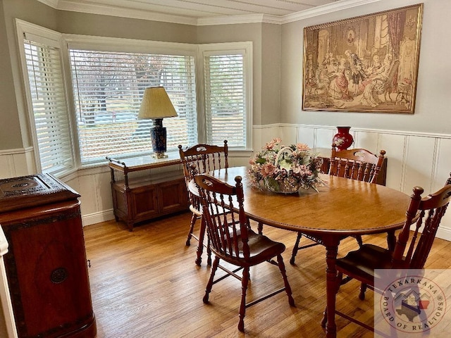 dining space with crown molding and light wood-type flooring