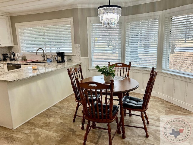 dining space featuring crown molding, a healthy amount of sunlight, a chandelier, and sink