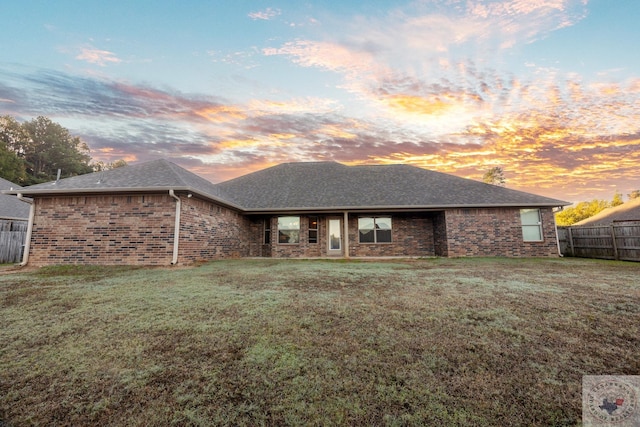 back house at dusk with a yard