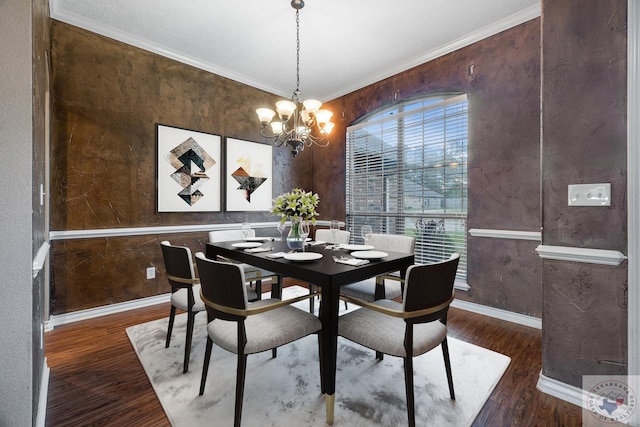 dining space with dark wood-type flooring, ornamental molding, and a chandelier