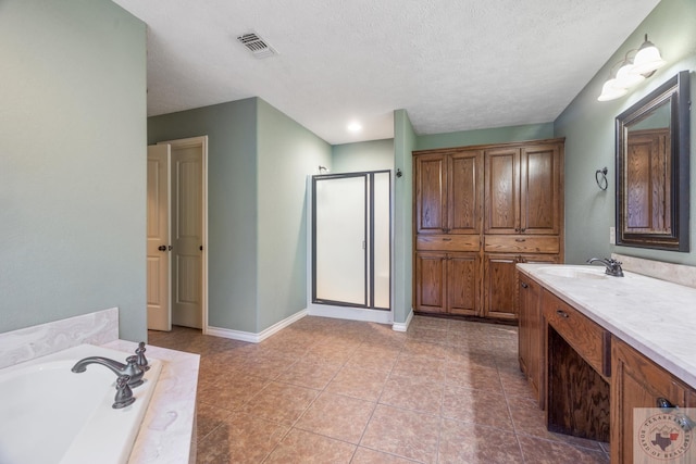 bathroom with a textured ceiling, vanity, separate shower and tub, and tile patterned flooring