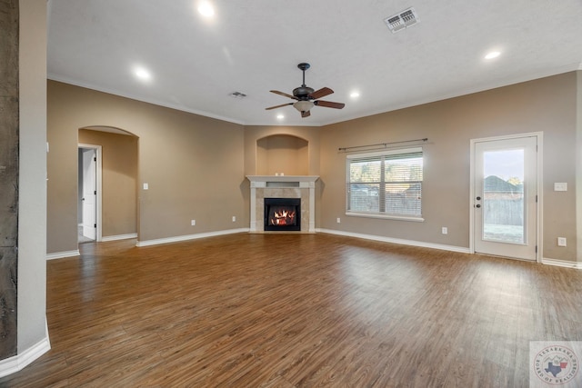 unfurnished living room with ceiling fan, ornamental molding, and dark hardwood / wood-style flooring