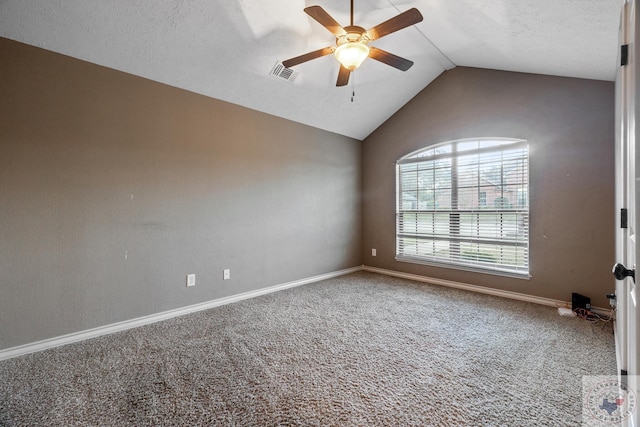 empty room featuring ceiling fan, a textured ceiling, lofted ceiling, and carpet flooring