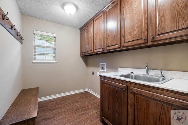 laundry room featuring electric dryer hookup, sink, hookup for a washing machine, dark wood-type flooring, and cabinets