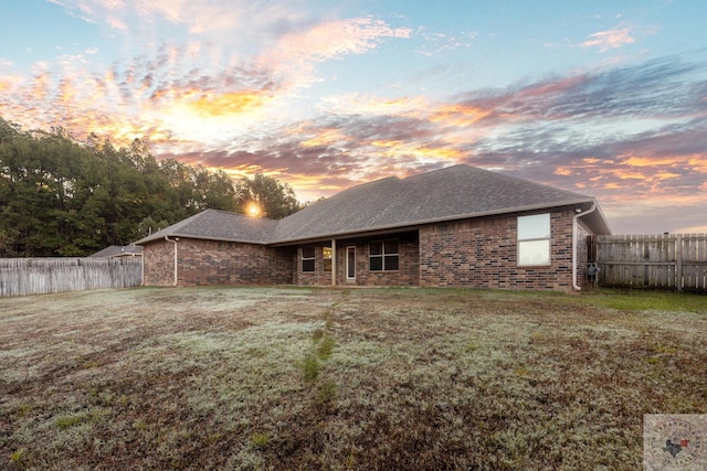 back house at dusk with a yard