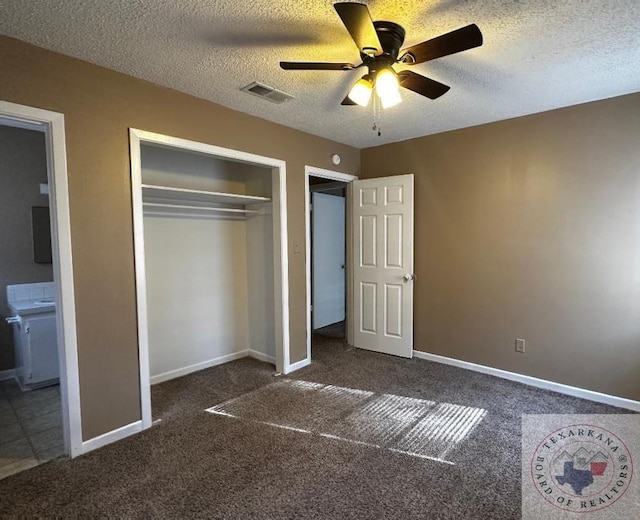 unfurnished bedroom with dark carpet, a textured ceiling, a closet, and ceiling fan