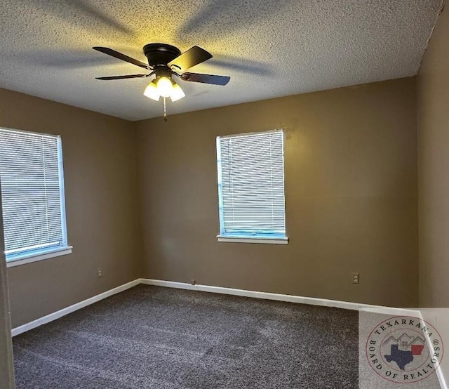 carpeted spare room with ceiling fan, plenty of natural light, and a textured ceiling