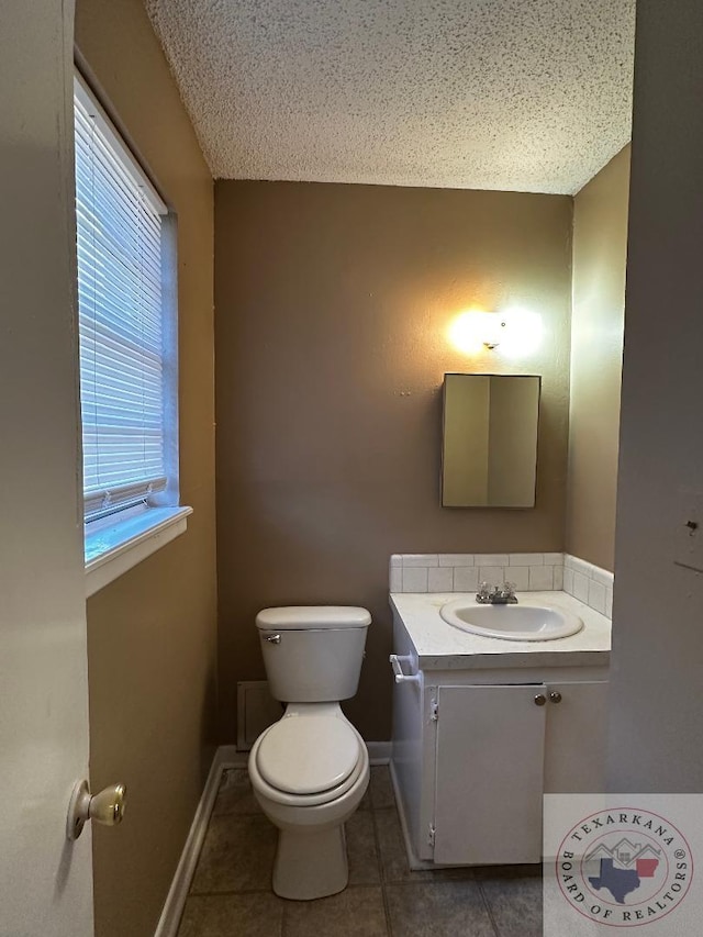 bathroom featuring a textured ceiling, tile patterned floors, vanity, and toilet