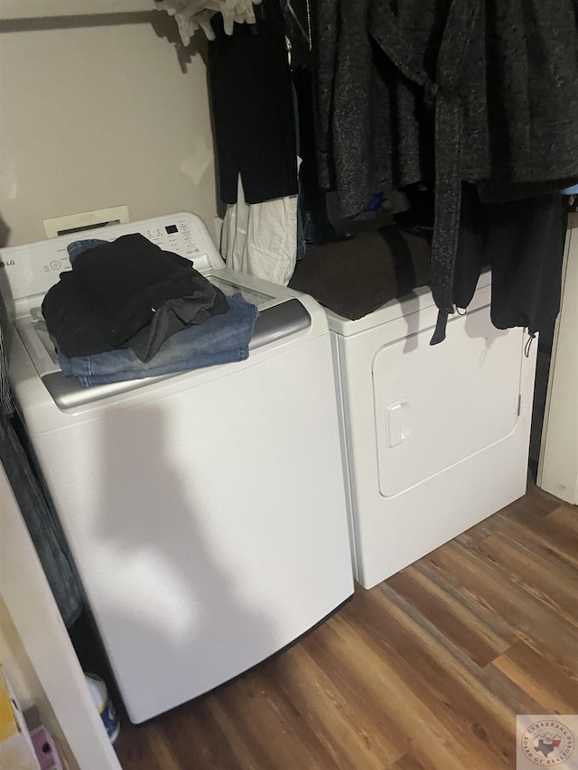 laundry area with dark hardwood / wood-style floors and independent washer and dryer