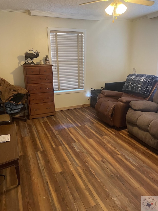 living room featuring a textured ceiling, dark hardwood / wood-style floors, ceiling fan, and ornamental molding