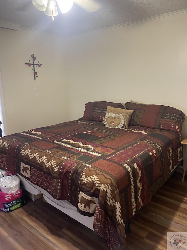 bedroom with ceiling fan, dark wood-type flooring, and ornamental molding