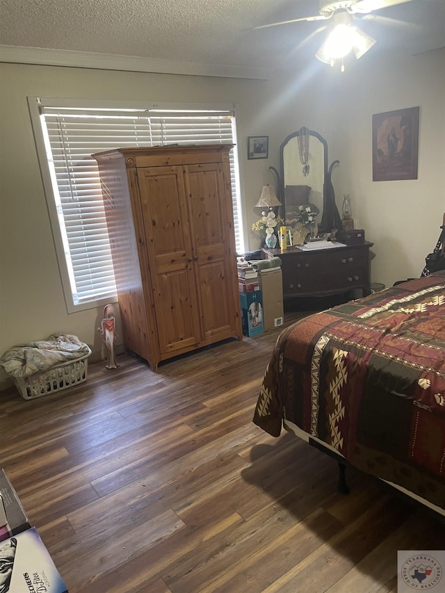 bedroom featuring ceiling fan, dark hardwood / wood-style floors, and a textured ceiling