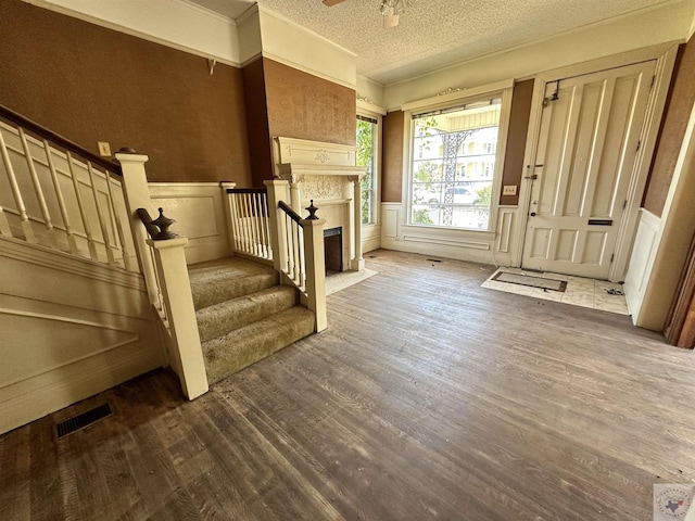 entryway with ceiling fan, a textured ceiling, and dark hardwood / wood-style flooring