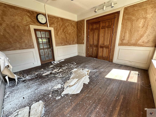 miscellaneous room featuring hardwood / wood-style flooring and a textured ceiling