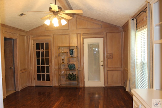 foyer entrance featuring ceiling fan, a textured ceiling, dark hardwood / wood-style flooring, and vaulted ceiling