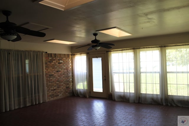 unfurnished room featuring ceiling fan and a skylight