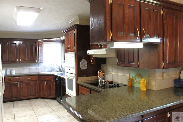 kitchen with sink, dark stone countertops, light tile patterned floors, and decorative backsplash