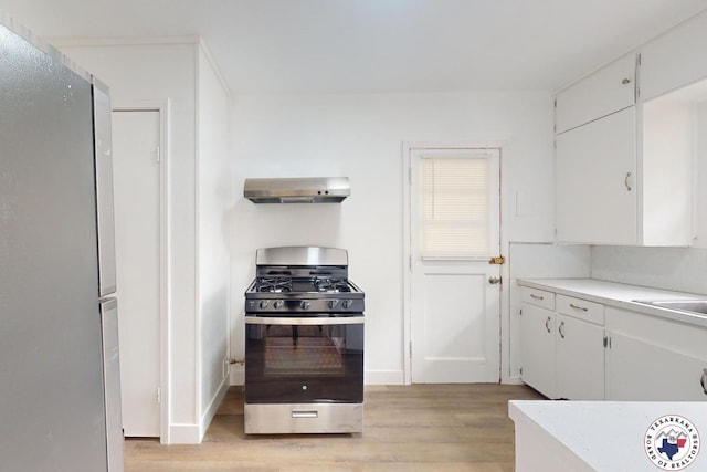 2451 Oaklawn Dr, Texarkana, TX 75501 - kitchen featuring wall chimney range hood, light wood-type flooring, light countertops, white cabinets, and appliances with stainless steel finishes