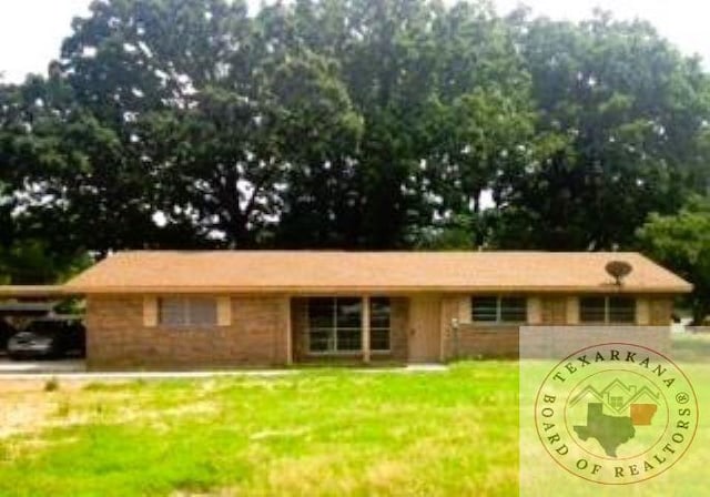 ranch-style home with an attached carport and a front yard