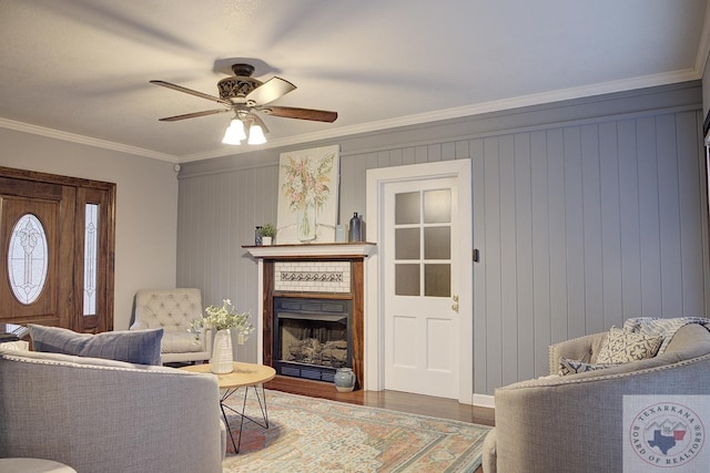 living room with ceiling fan, hardwood / wood-style floors, crown molding, and wooden walls