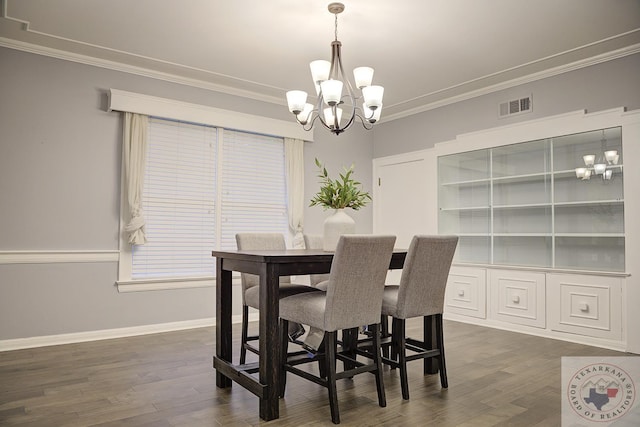 dining area with ornamental molding, an inviting chandelier, and dark wood-type flooring