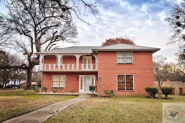 view of front facade featuring a balcony and a front lawn