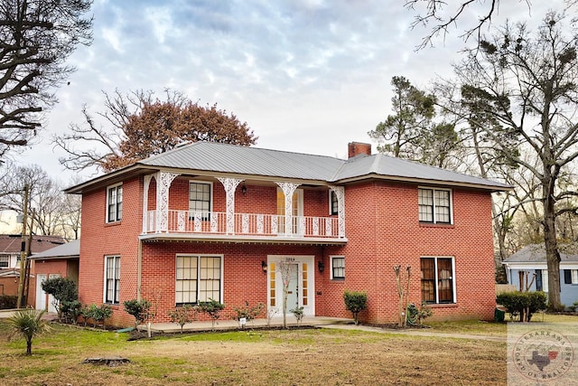 view of front facade with a balcony and a front yard