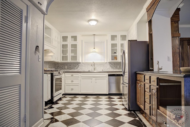 kitchen with white cabinetry, stainless steel appliances, sink, hanging light fixtures, and crown molding